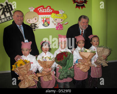 Prime Minister of Rhineland-Palatinate, Kurt Beck (R) is greeted by children at the childrens' pavillion of the 2010 Expo in Shanghai, China, 27 October 2010. He is joined by State Secretary for Economic Affairs Siegfried Englert. Beck is on a a state visit to china. Photo: Imke Hendrich Stock Photo