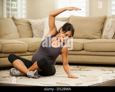 Pregnant Hispanic woman stretching Stock Photo