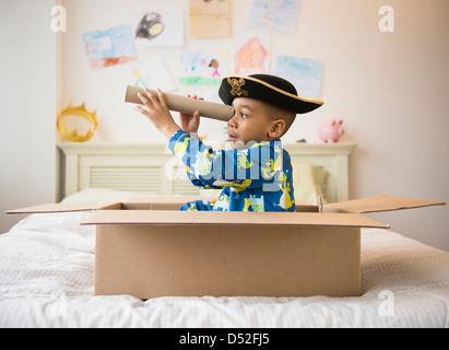 African American boy playing in cardboard box Stock Photo