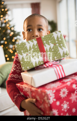 African American boy carrying Christmas presents Stock Photo