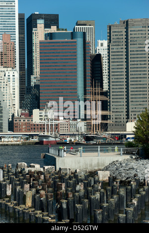 WOOD PILINGS PIER ONE BROOKLYN EAST RIVER TO MANHATTAN SKYLINE NEW YORK CITY USA Stock Photo