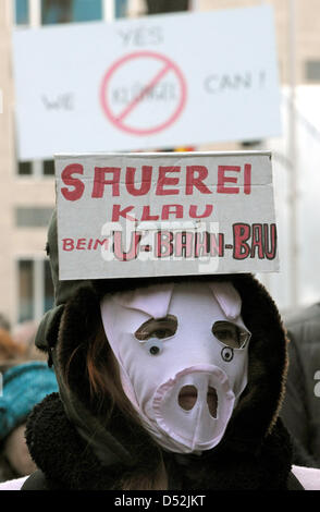 A woman with a pigs mask reading in English 'What a mess, thievery at the subway construction site' during a demonstration against alleged botch at the construction of Cologne's new subway lines in Cologne, Germany, 03 March 2010. Cologne marked the collapse of its historic city archive exactly one year ago with a minute's silence. Lord Mayor Roters invited surviving dependants, ar Stock Photo