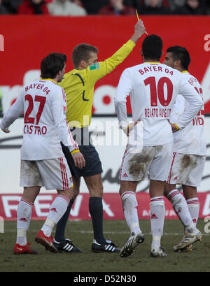 Referee Jochen Drees (2-L) shows Leverkusen's Arturo Vidal (R) the yellow card during German Bundesliga match Nuremberg vs Bayer Leverkusen at easyCredit-Stadium in Nuremberg, Germany, 07 March 2010. The match ended 3-2. Also depicted are Leverkusen's Gonzalo Castro (L) and Renato Augusto. Photo: DANIEL KARMANN (ATTENTION: EMBARGO CONDITIONS: The DFL permits the further utilisation Stock Photo