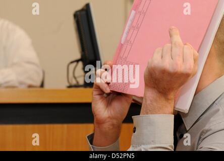 Edis K., alleged blackmailer of US topmodel Cindy Crawford (not depicted), shows a camera the finger at the County Court in Kirchheim unter Teck, Germany, 09 March 2010. Confessed 26-year-old K. is accused of blackmailing Crawford with a picture of her daughter. Photo: MARIJAN MURAT Stock Photo