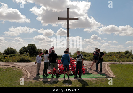 Visitors around a large cross beside the Lochnagar mine crater near La Boisselle, Somme, Picardy, France. Stock Photo