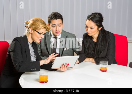 Group of three business people discussing and planning project at meeting in office. Stock Photo