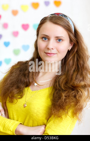 portrait of a beautiful young cheerful brunette smiling girl with long red hair in the yellow blouse Stock Photo