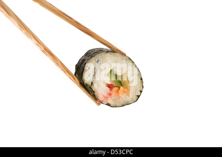 an image of a single sushi roll between a pair of chopsticks Stock Photo