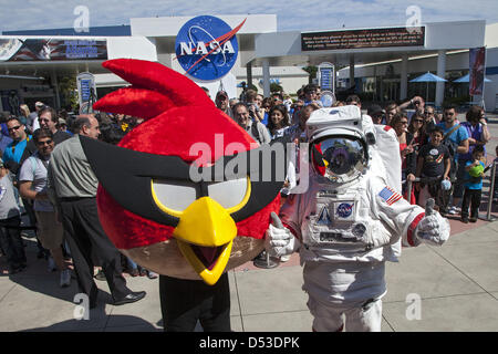 A character in an astronaut spacesuit and Red Bird, one of the Angry Bird characters, welcome visitors to the Angry Birds Space Encounter grand opening ceremony at the Kennedy Space Center in Cape Canaveral, Florida. Finland-based Rovio Entertainment, the creator of the Angry Birds Space game partnered with Kennedy Space Center to bring the beloved characters to life. It is the first Angry Birds interactive exhibit in the United States designed for people of all ages. Stock Photo