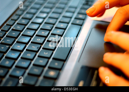 Hands typing on a laptop keyboard Stock Photo