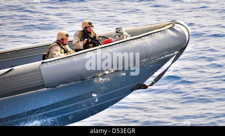 US Navy sailors of the visit, board, search and seizure team assigned to the littoral combat ship USS Freedom conduct tactical exercises in a rigid-hull inflatable boat April 7, 2010 in the Pacific Ocean. Stock Photo