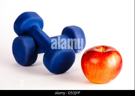 Blue dumbbells and red apple isolated on a white background Stock Photo