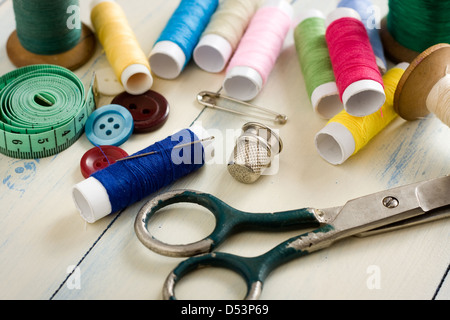 Spools of threads and buttons on old wooden table Stock Photo