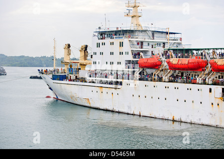 Tug Assisting the Nicobar Ferry From Mumbai,India calling at Port Blair packed with Passengers from the mainland,Andaman Islands Stock Photo