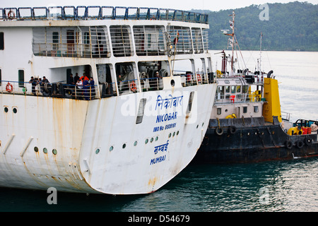 Tug Assisting the Nicobar Ferry From Mumbai,India calling at Port Blair packed with Passengers from the mainland,Andaman Islands Stock Photo