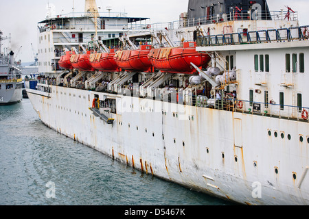 Tug Assisting the Nicobar Ferry From Mumbai,India calling at Port Blair packed with Passengers from the mainland,Andaman Islands Stock Photo