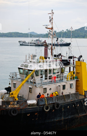 Tug Assisting the Nicobar Ferry From Mumbai,India calling at Port Blair packed with Passengers from the mainland,Andaman Islands Stock Photo