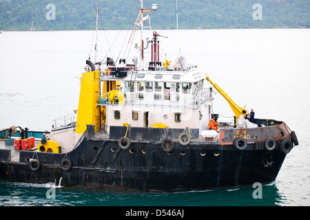 Tug Assisting the Nicobar Ferry From Mumbai,India calling at Port Blair packed with Passengers from the mainland,Andaman Islands Stock Photo