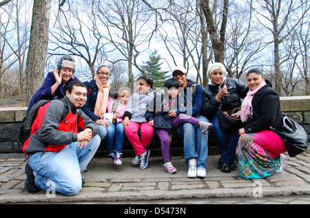 Portrait of Hispanic friends sitting on park bench in Central Park, New York City, Manhattan, USA. Stock Photo