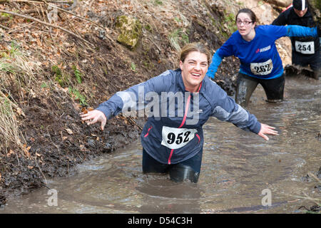 Kilmarnock, UK. 24 March 2013. Organised Mud Run at Craufurdland Castle Estate, near Kilmarnock.  Despite the recent bad weather approximately 200 Mud Runners took part in the annual run across the estate. The route was over 10 kilometres through woodlands, across rivers and water filled ditches Many of the runners were being sponsored for charities. Stock Photo