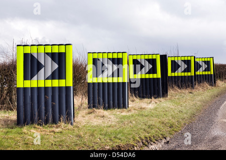 Road chevrons signs indicating a sharp right hand bend on a country road in the UK. Stock Photo