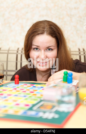 Caucasian woman playing board games in domestic room Stock Photo