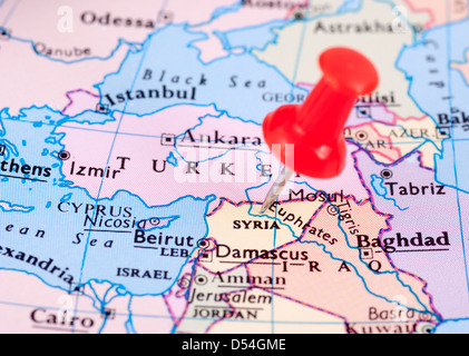 Red Pin stuck in a map showing Syria Stock Photo