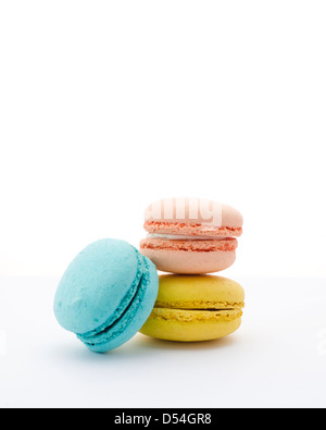 French Macaron cookies in peach, blueberry and lemon against white background. Stock Photo