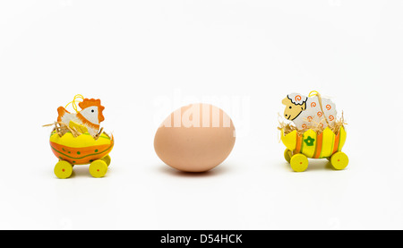 A chicken and a cow staring at an egg Stock Photo
