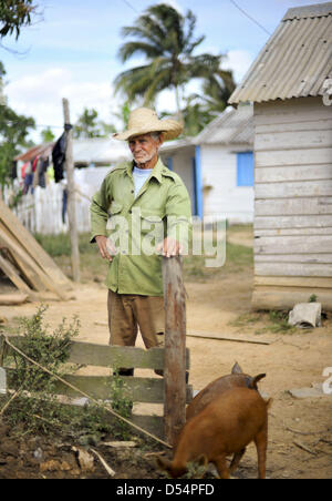 March 14, 2013 - Havana, Cuba - A tobacco farmer watches as his son (not seen) teaches his daughter to plow land in search of worms at their home in a rural part of vinales in Pinar del Rio, Cuba on Saturday, March 16, 2013. It takes the family hours to collect enough bait worms to go fishing; one of the ways the family survives in a climate where the average citizen making less than a dollar per day. (Credit Image: © Josh Edelson/ZUMAPRESS.com) Stock Photo