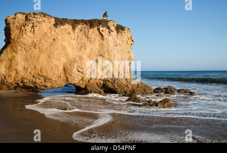 Visitor sits atop formation at El Matador State Beach in Southern California Stock Photo