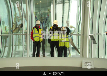 London, UK. 24th March 2013. A guest poses for photos infront of a large concave mirror on the observation tower of the ArcelorMittal Orbit Credit:  david mbiyu / Alamy Live News Stock Photo