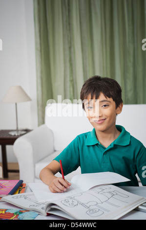 Boy smiling while doing his homework Stock Photo