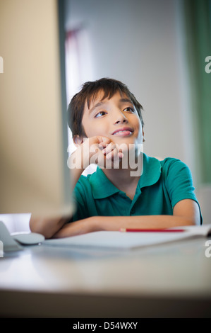 Boy day dreaming while doing his homework Stock Photo
