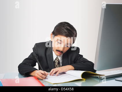 Boy imitating like businessman signing documents Stock Photo