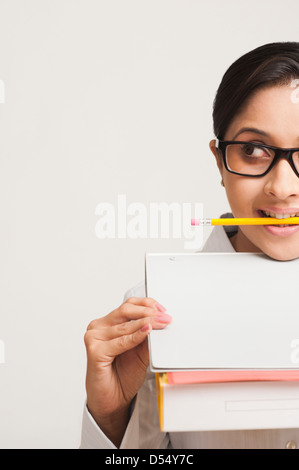 Woman holding pencil in her mouth Stock Photo - Alamy