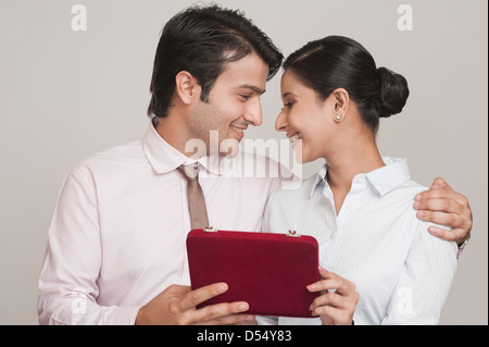 Businessman giving gift to a businesswoman in an office Stock Photo