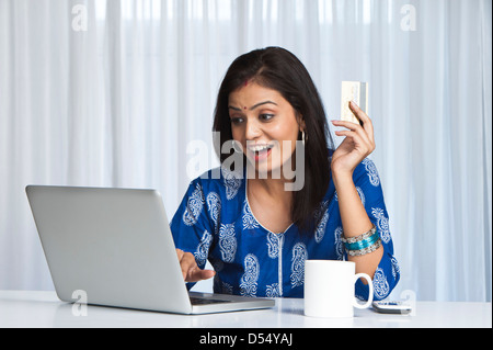 Young woman doing online shopping with a laptop Stock Photo
