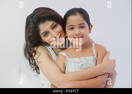 Portrait of a woman hugging her daughter from behind Stock Photo