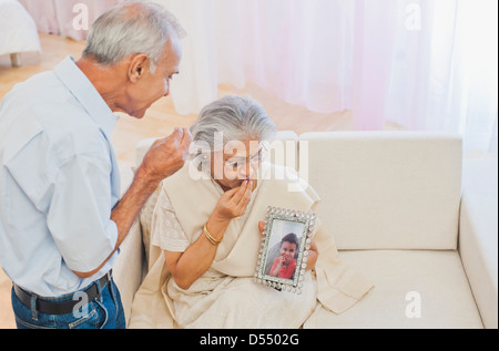Senior couple looking emotional while looking at their grandchilds photograph Stock Photo