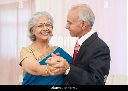 Senior couple dancing at their anniversary and smiling Stock Photo