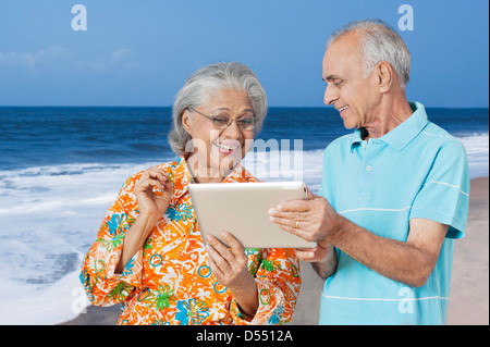 Senior couple looking at a digital tablet and smiling Stock Photo