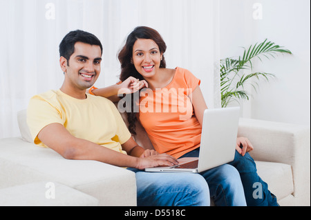 Couple using a laptop on a couch Stock Photo