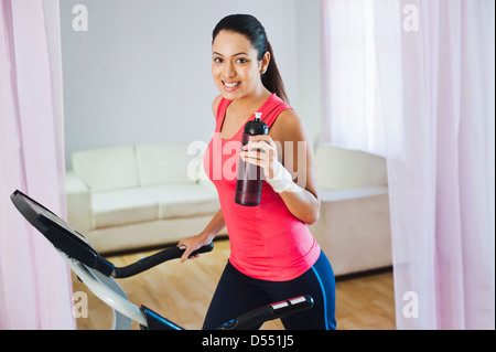 Happy woman running on a treadmill Stock Photo