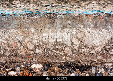 Sliced cross section of a street with exposed gravel underneath while maintenance work for utilities company is in progress Stock Photo