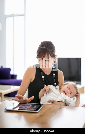 Businesswoman holding crying son Stock Photo
