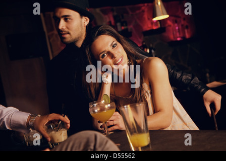 Smiling pretty woman at the bar enjoying with her friends Stock Photo