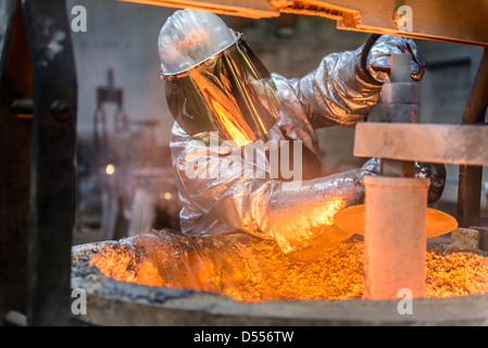 Workers cleaning metal flask in factory