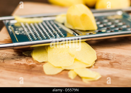 Close up of potato on grater Stock Photo