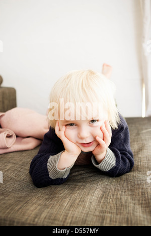 Smiling boy laying on bed Stock Photo